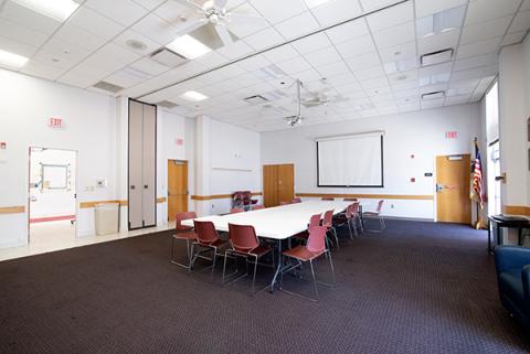 large meeting room with conference table and screen