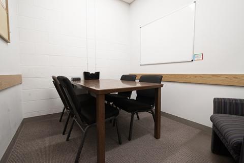 small study room with table, chairs, and whiteboard