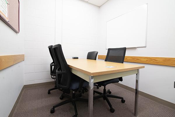 small study room with table, chairs, and whiteboard